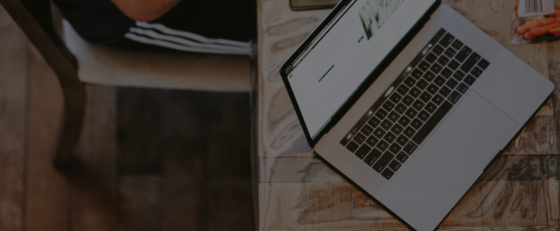 Open laptop on a wooden desk, dimmed